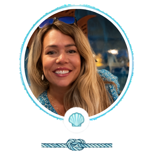 Woman smiling, wearing sunglasses on head, framed by a blue circular design and shell motif.
