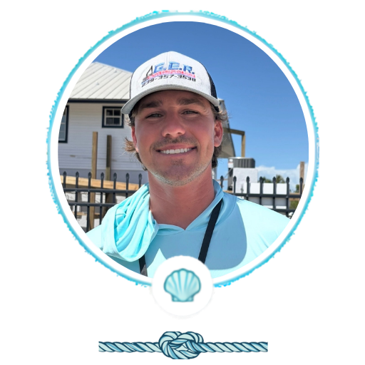 Smiling person in a cap and light blue shirt, outdoors.