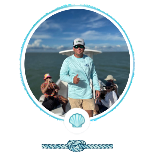 Man in blue shirt gives thumbs up on boat with others, ocean backdrop.