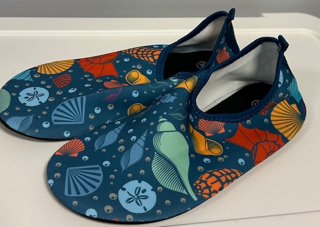 Colorful aquatic-themed water shoes with seashell and sea life patterns on display.