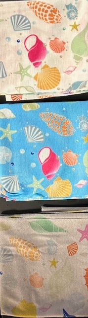 Three fabric pieces with colorful seashell and starfish patterns.